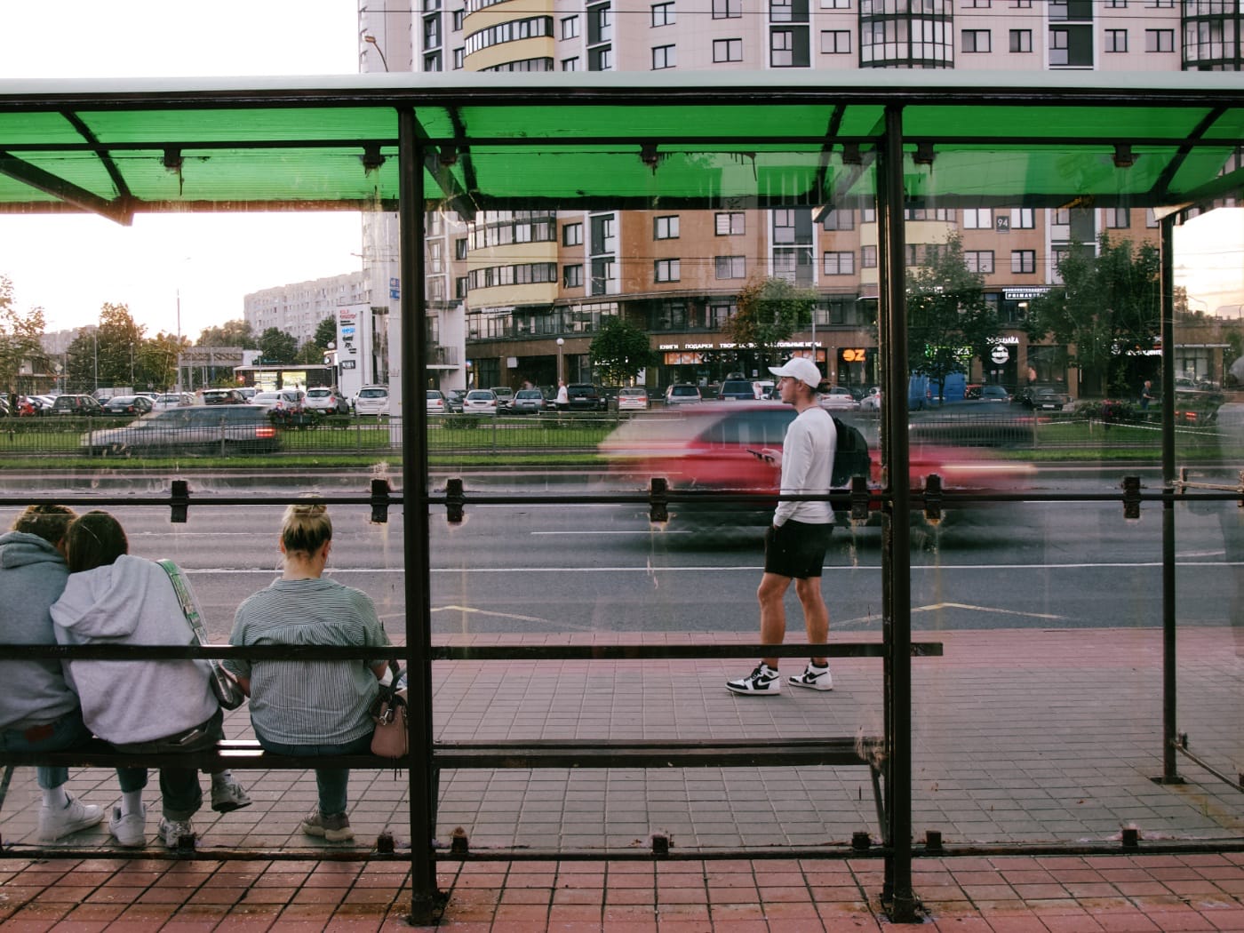 Люди ждут транспорта на остановке