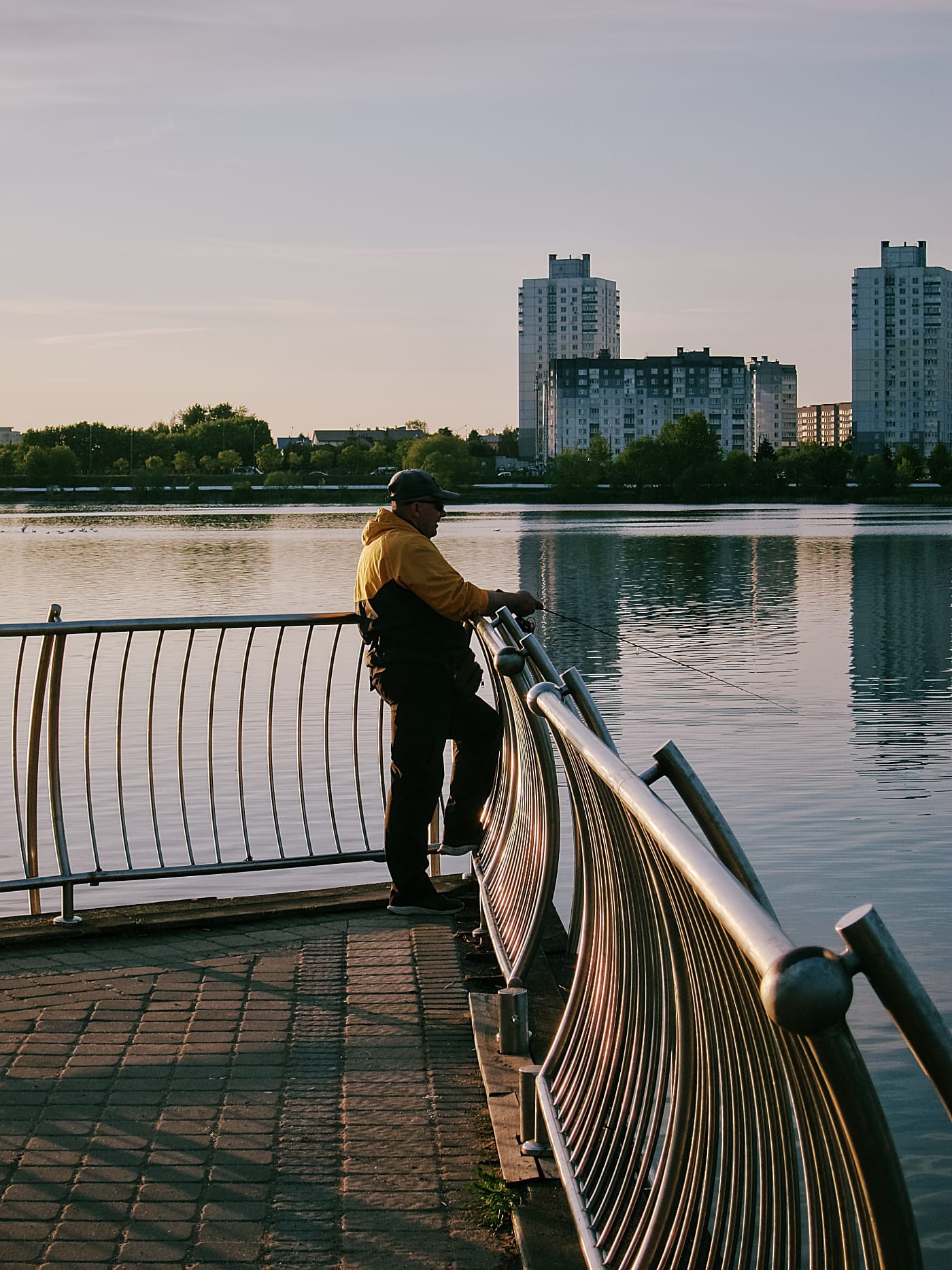 Рыбак на пирсе Чижовского водохранилища в Минске