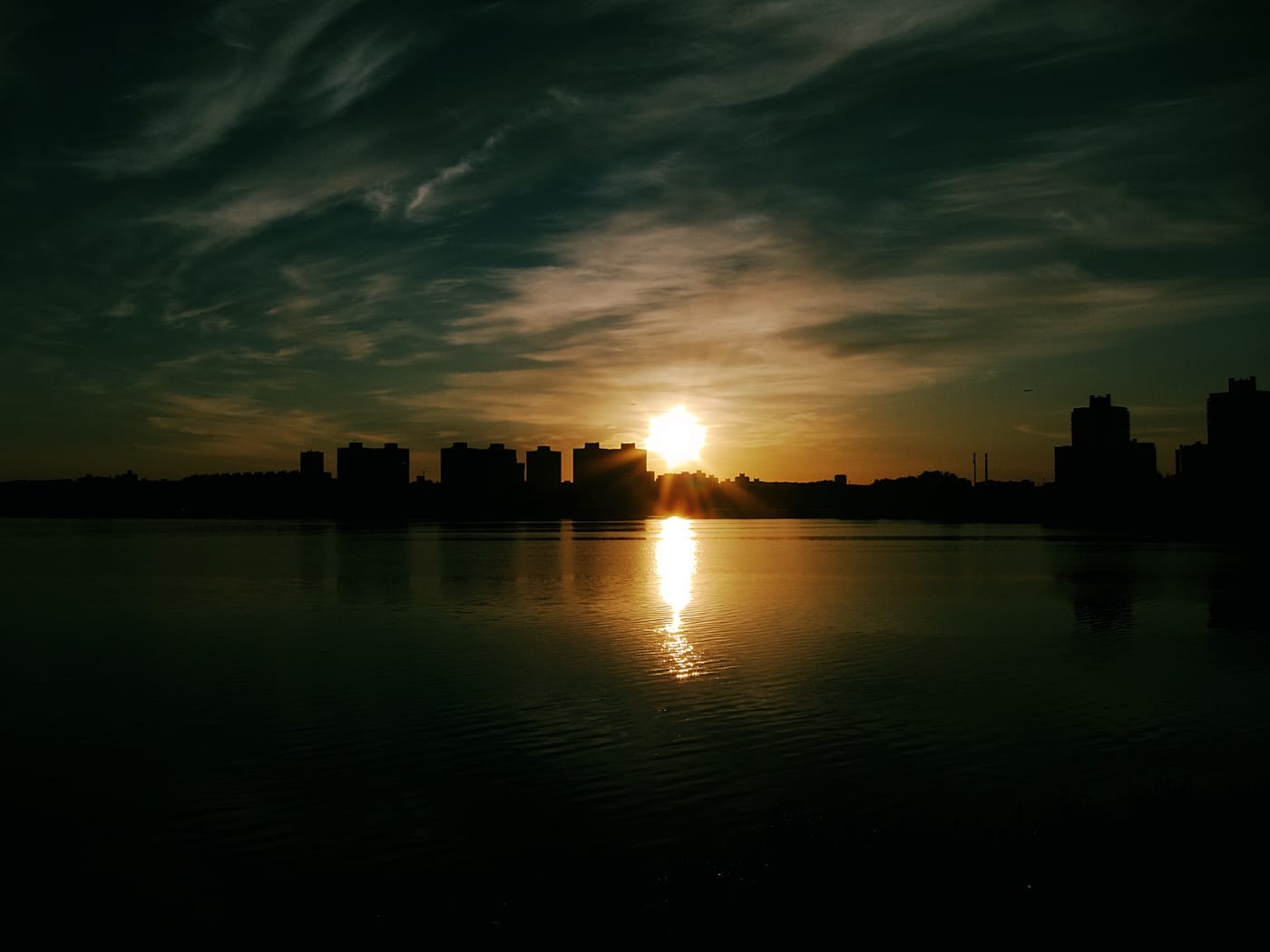 Утка плывёт на фоне красивого заката на Чижовском водохранилище в Минске