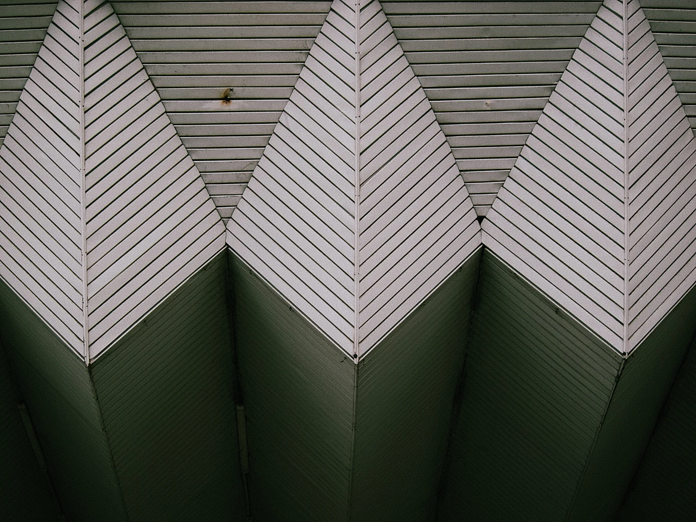 A roof structure with alternating triangular elements made of wooden panels.