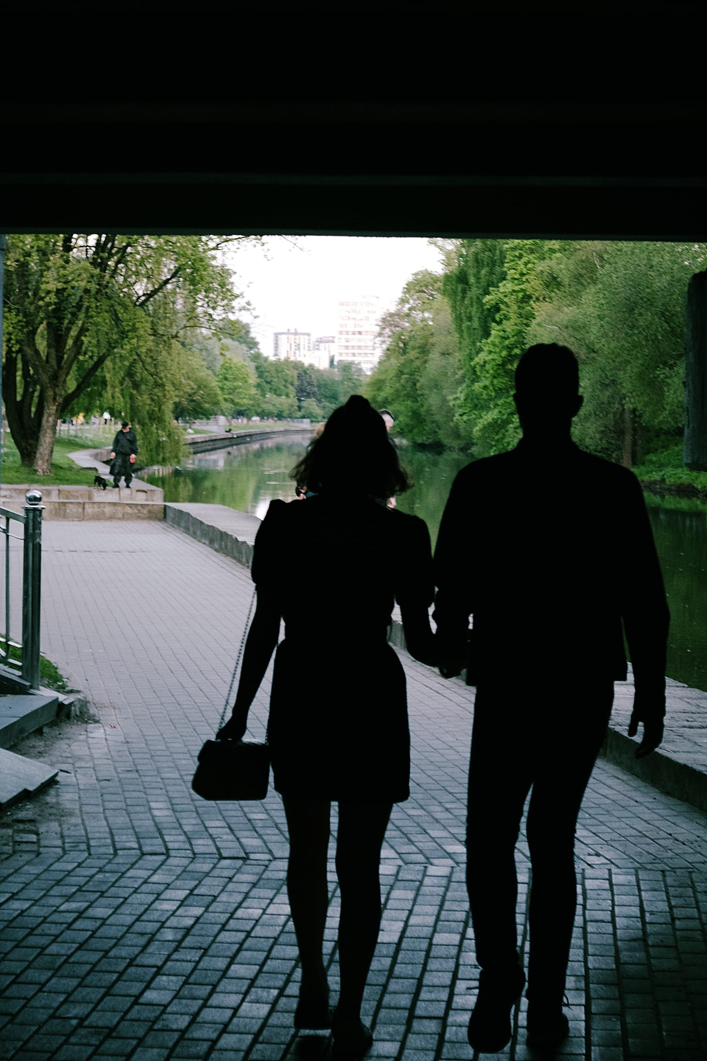 A man and a woman walk holding hands