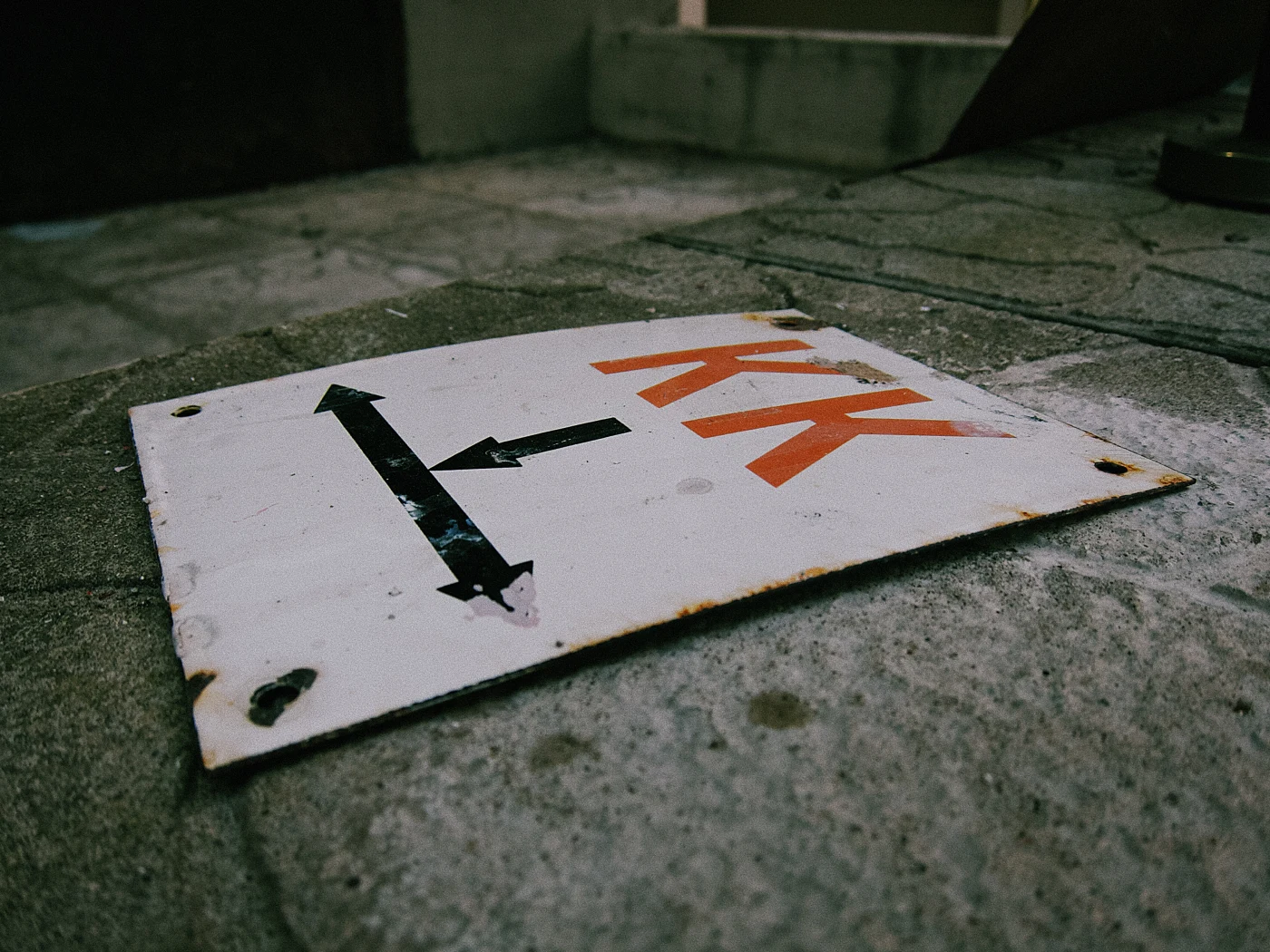 A sign with the letters “KK” and an arrow pointing to the side.