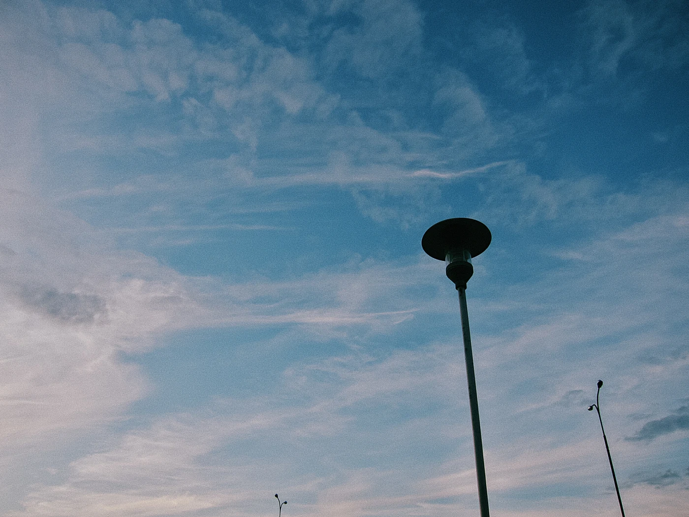 The sky with clouds and a streetlamp in the foreground.