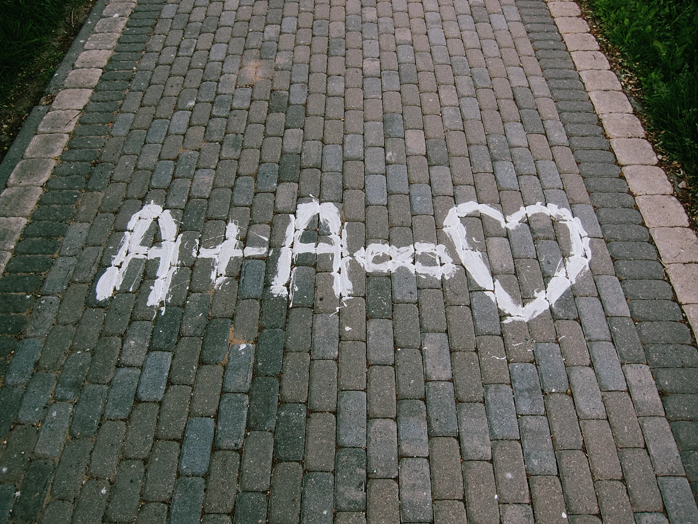 “A + A” and a heart written in white paint on the sidewalk.