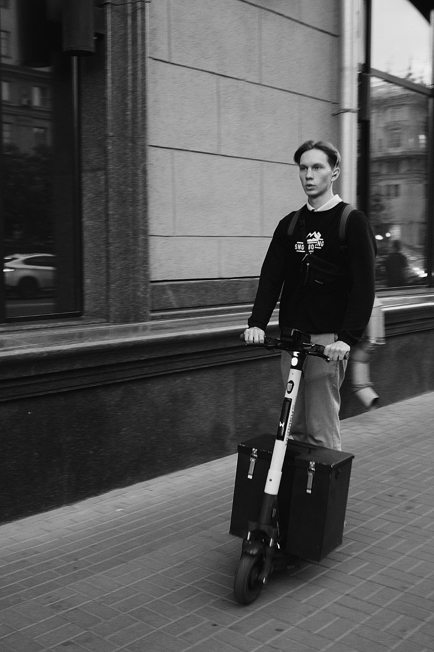 Чёрно-белая фотография: парень едет на самокате