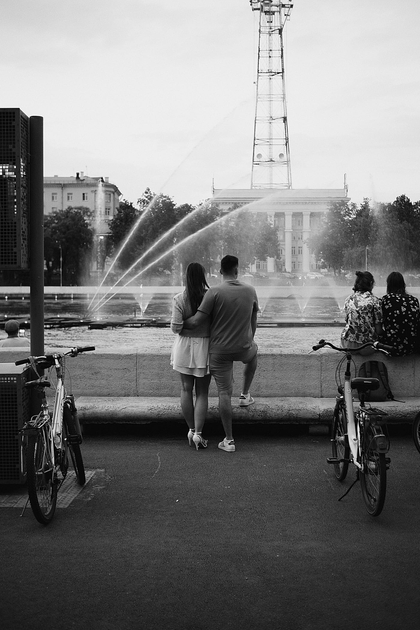 Парень и девушка, обнявшись смотрят на фотан