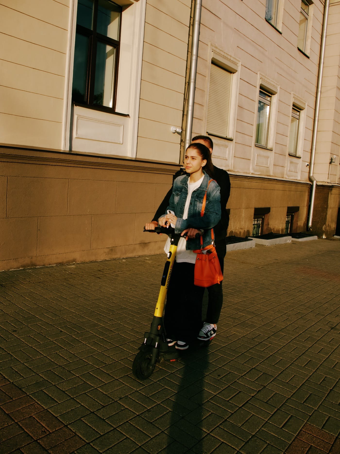 Парень и девушка едут на самокате по городу