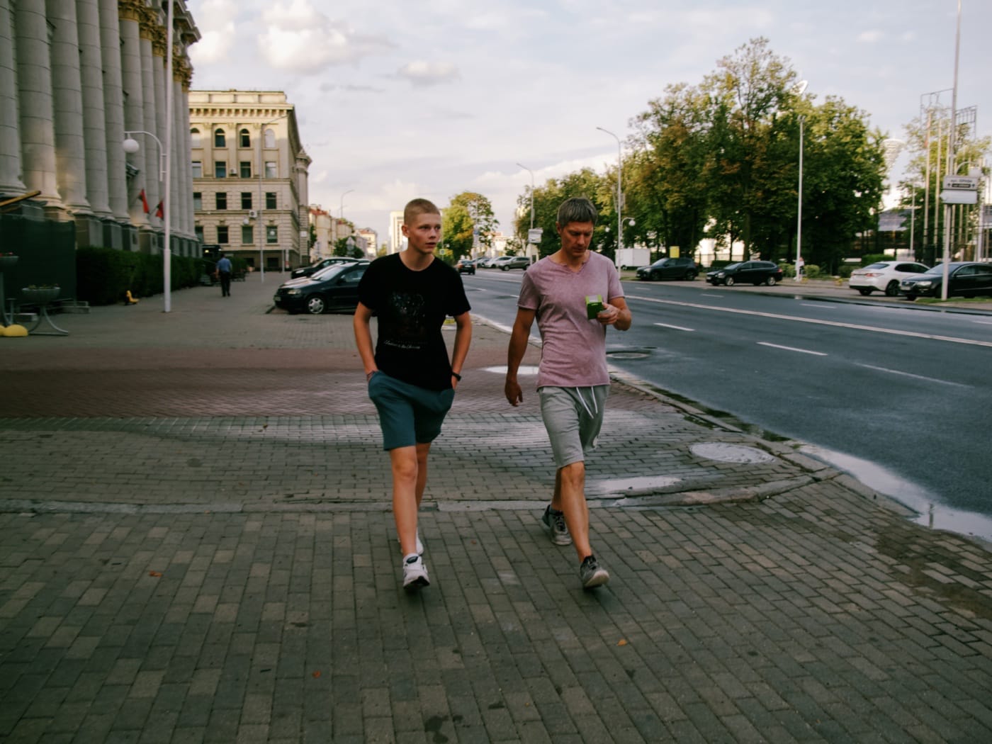 Отец с сыном идут по летнему городу
