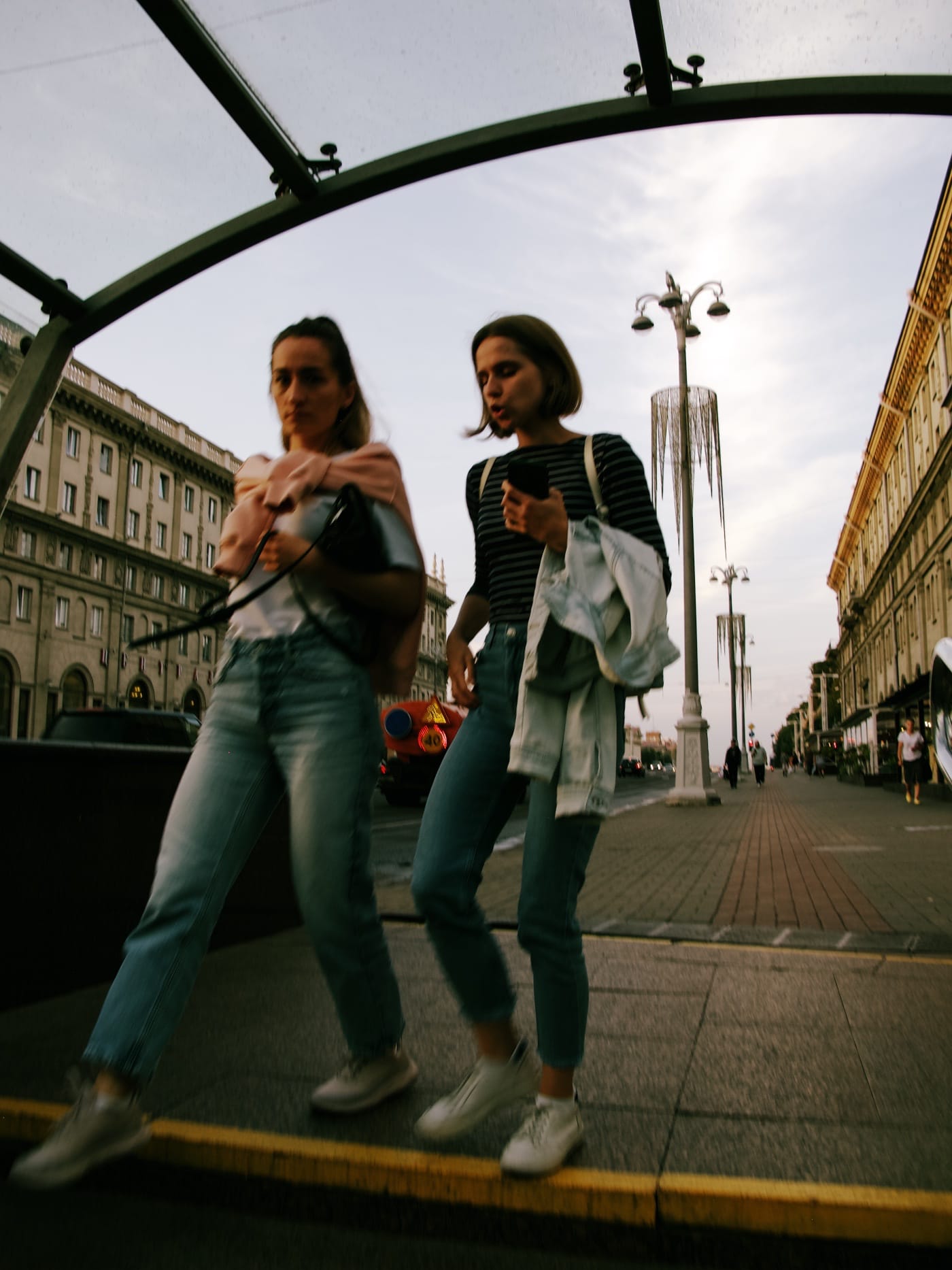 Две девушки спускаются в пешеходный переход