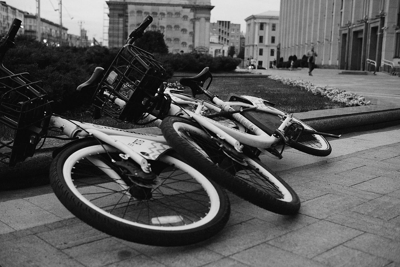 Два велосипеда лежат на тротуаре