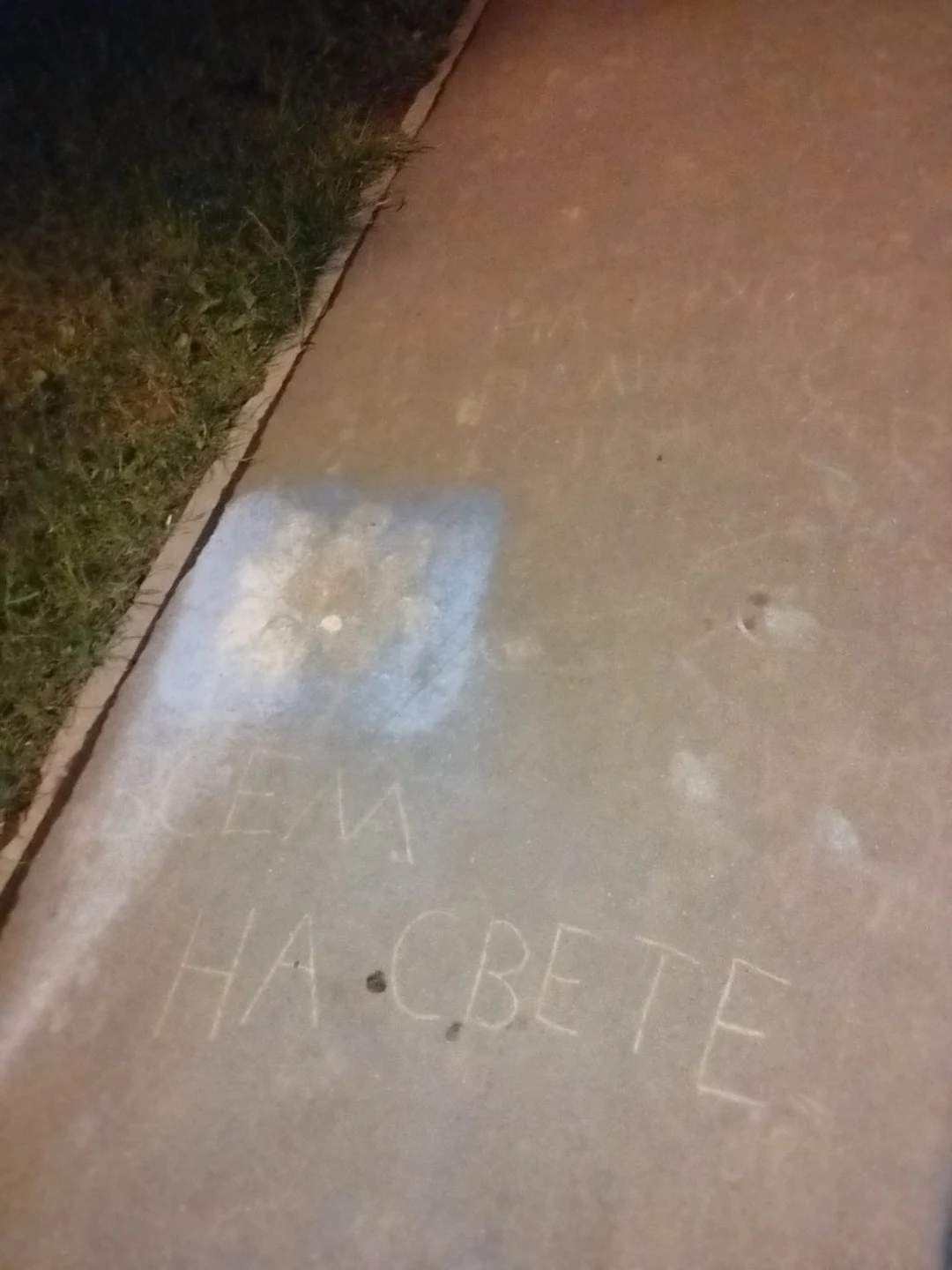 На тротуаре написано «ВСЕМ НА СВЕТЕ», рядом светлое пятно.