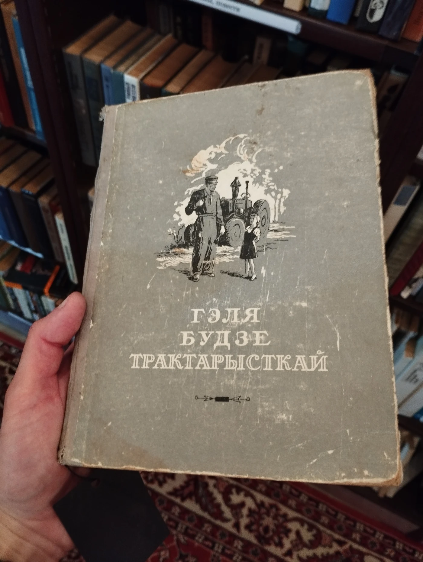На фото книга с названием «Гэля Будзе Тракарысткай», изображение человека и ребенка на обложке.