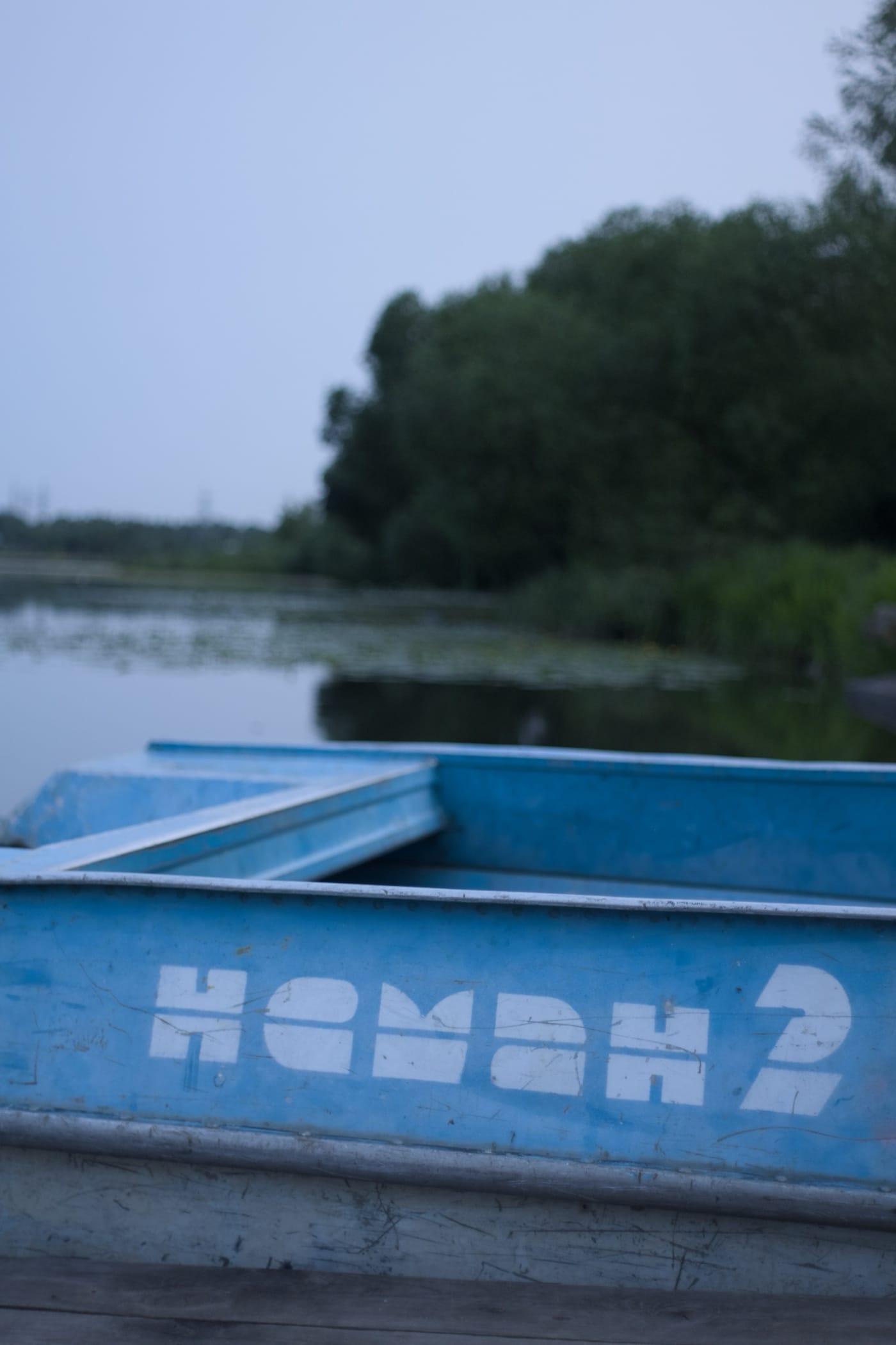 Голубая лодка с надписью «нёман 2» стоит на причале