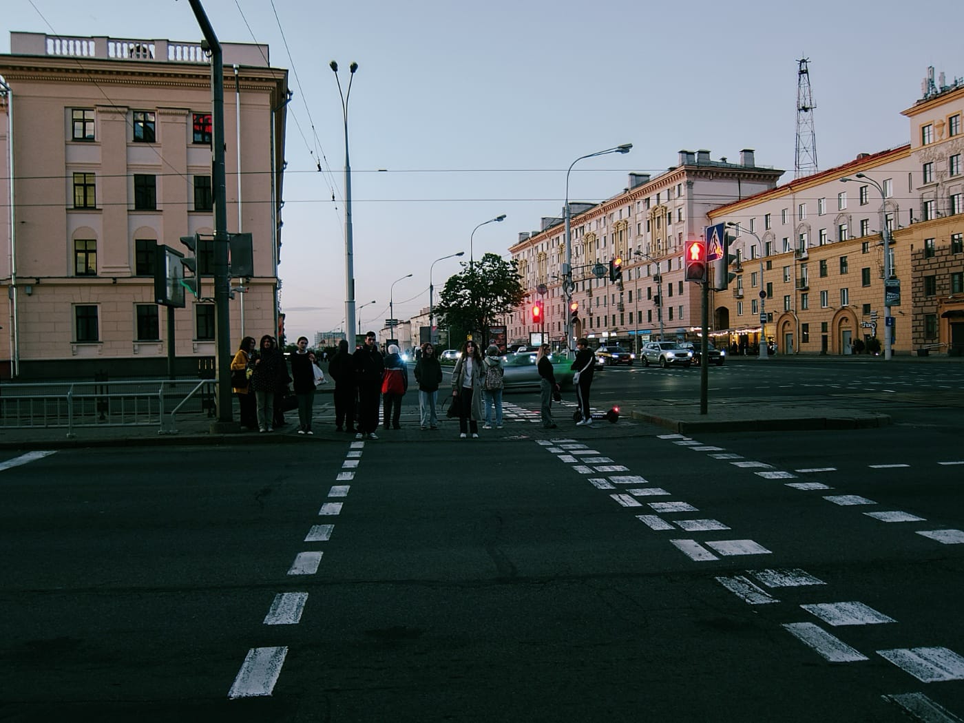 Люди стоят на пешеходном переходе на вечернем проспекте в Минске