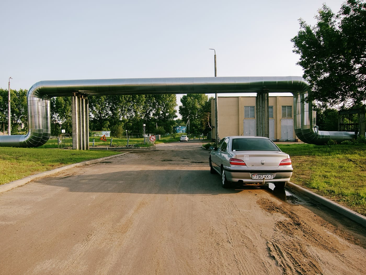 Теплотрасса и прикаркованный автомобиль в вечернем городе