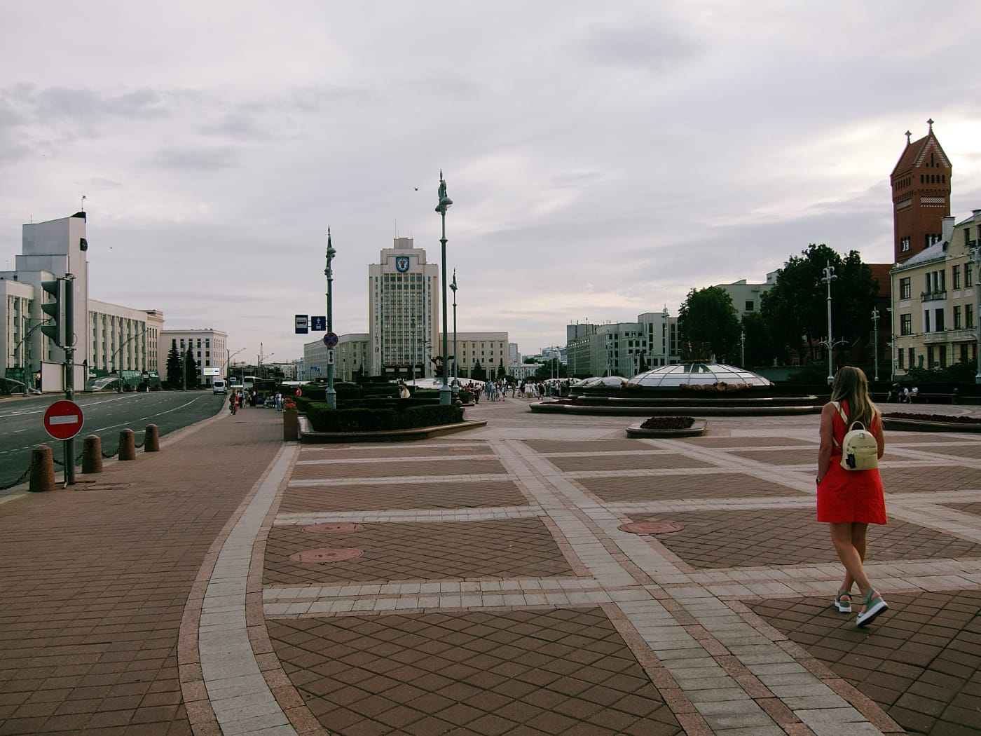 Девушка в красном платье идёт по площади в Минске