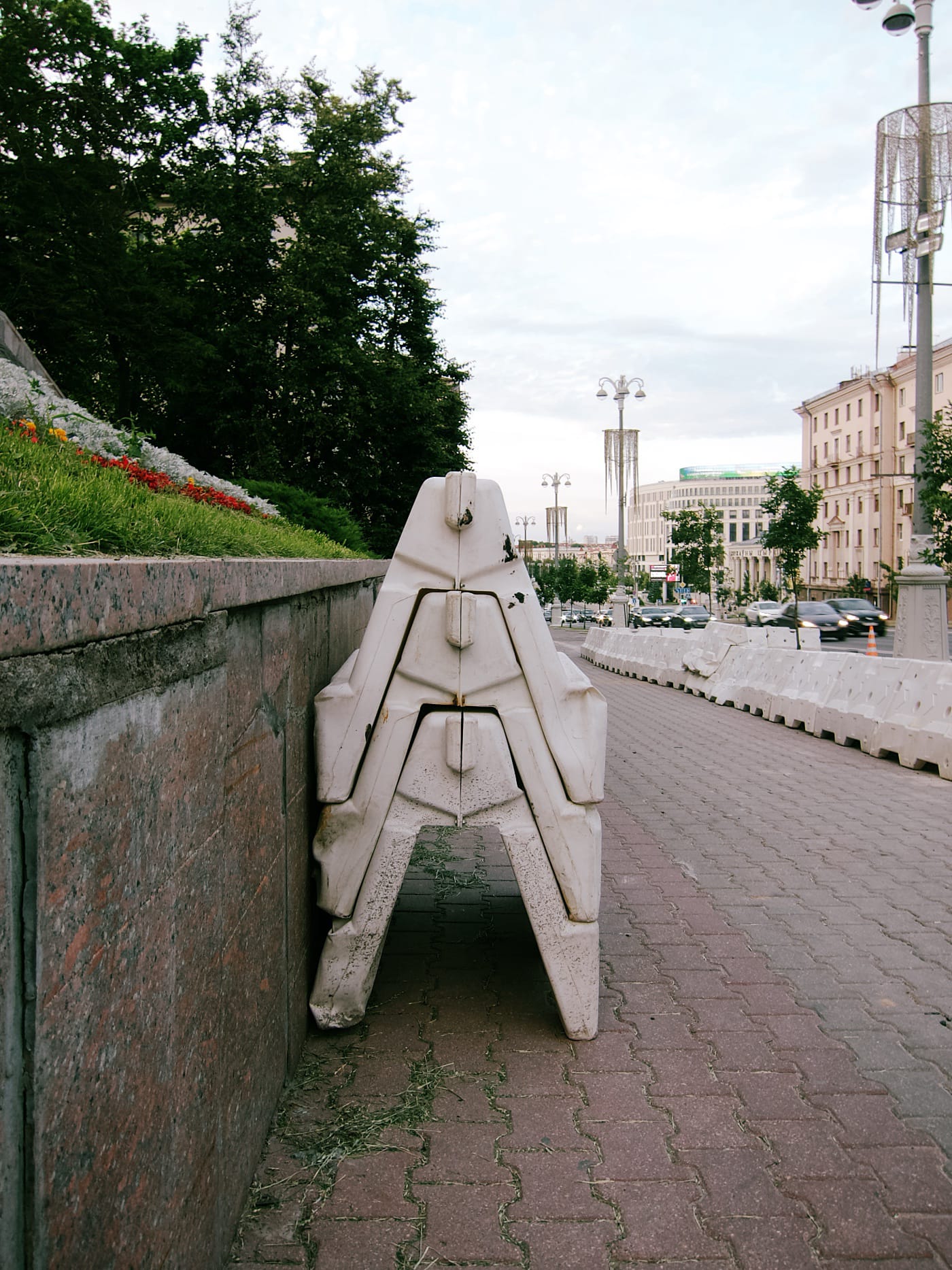 Пластмассовые дорожные ограждения стоят стопкой на тротуаре
