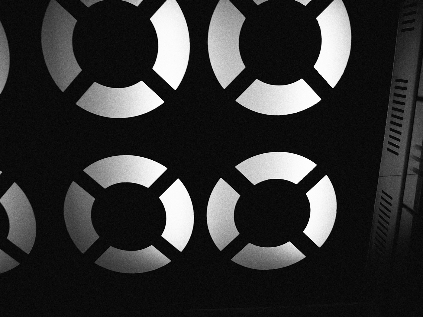 Чёрный фон с белыми кругами, напоминающими спасательные круги, расположенными в шахматном порядке.