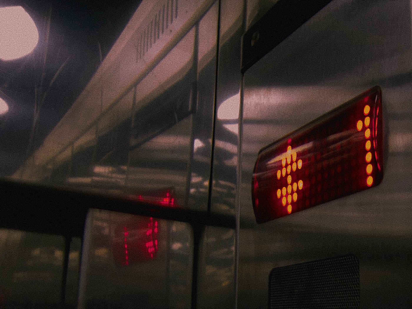 Красные огни на табло в лифте, отражение в металлической поверхности. Тёмная атмосфера.