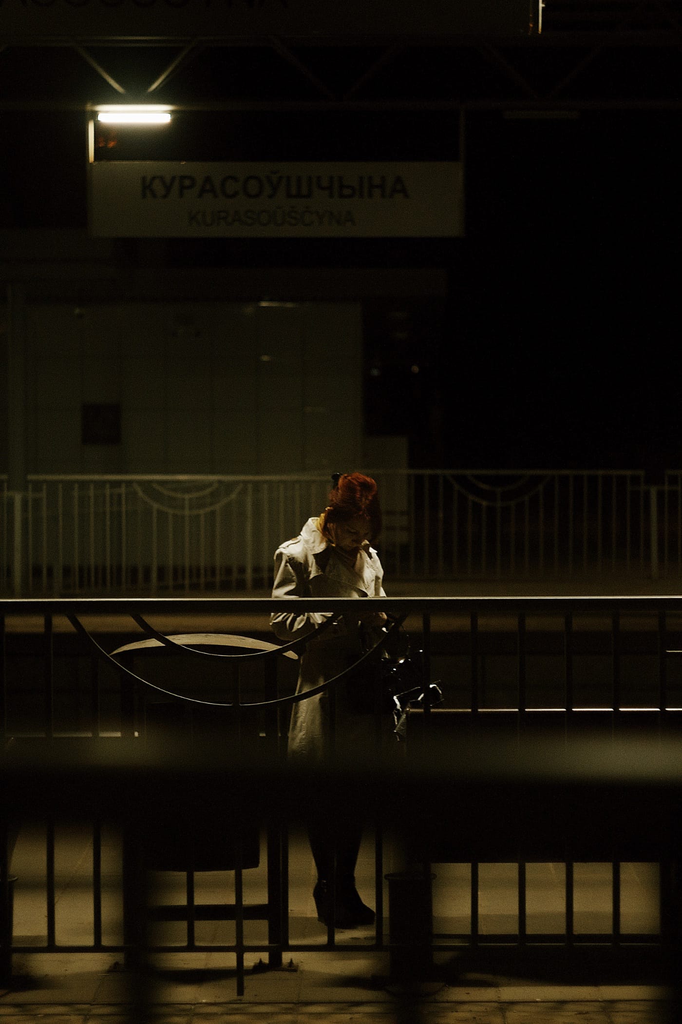 Женщина стоит на ночном пероне
