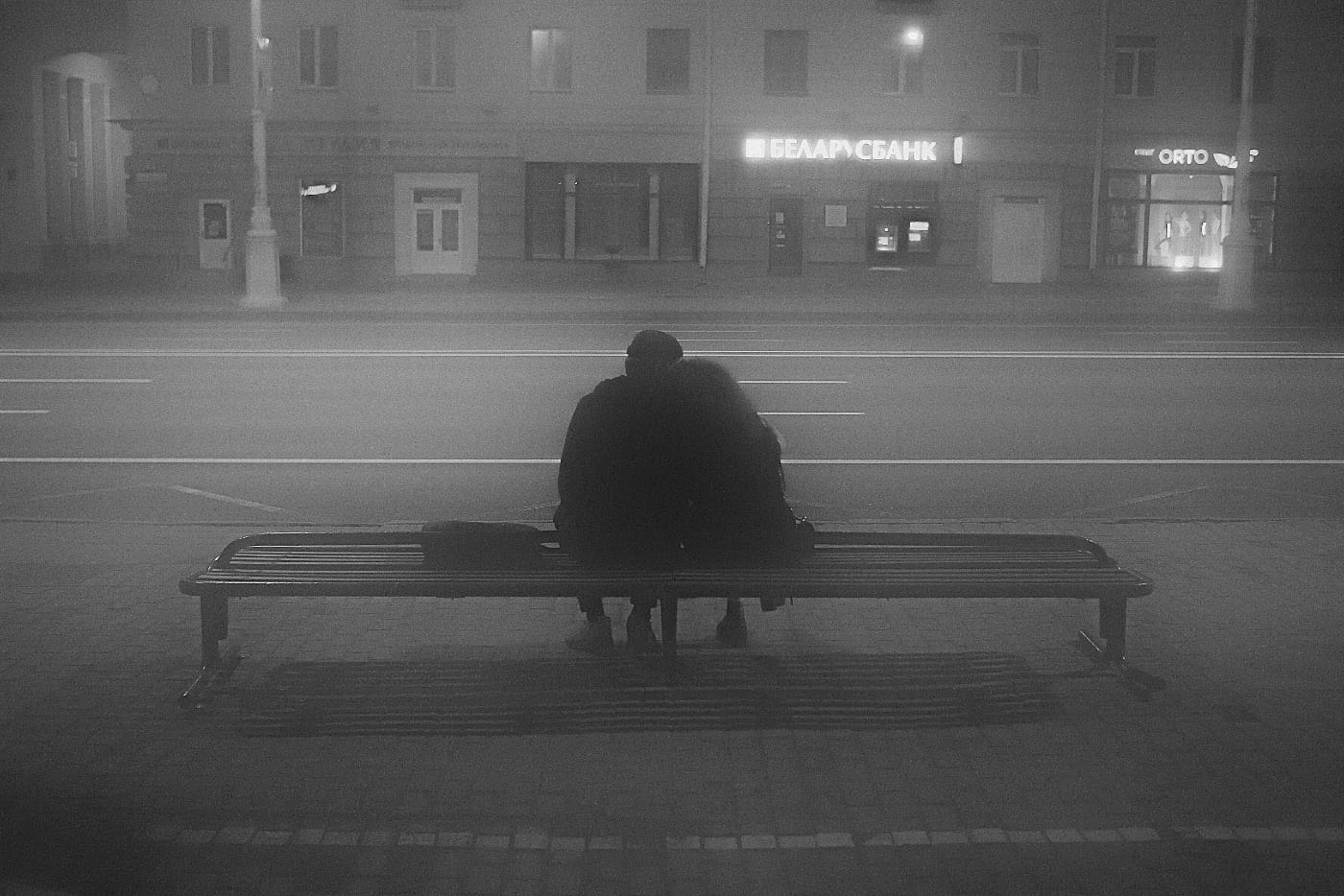 Девушка и парень сидят на скамейе в обнимку в тумане