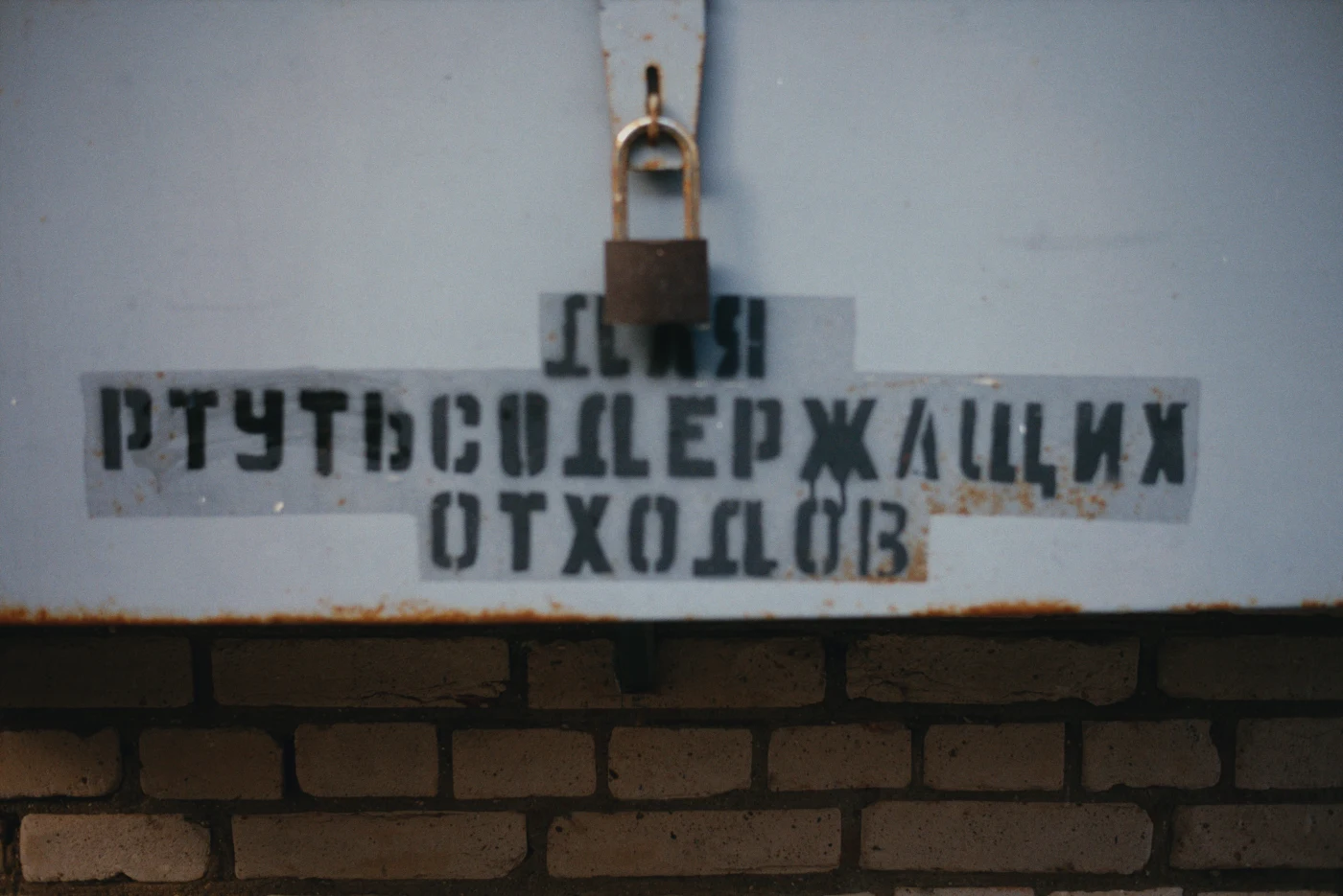 Надпись на стене: «Сдача ртутьсодержащих отходов», замок на двери.
