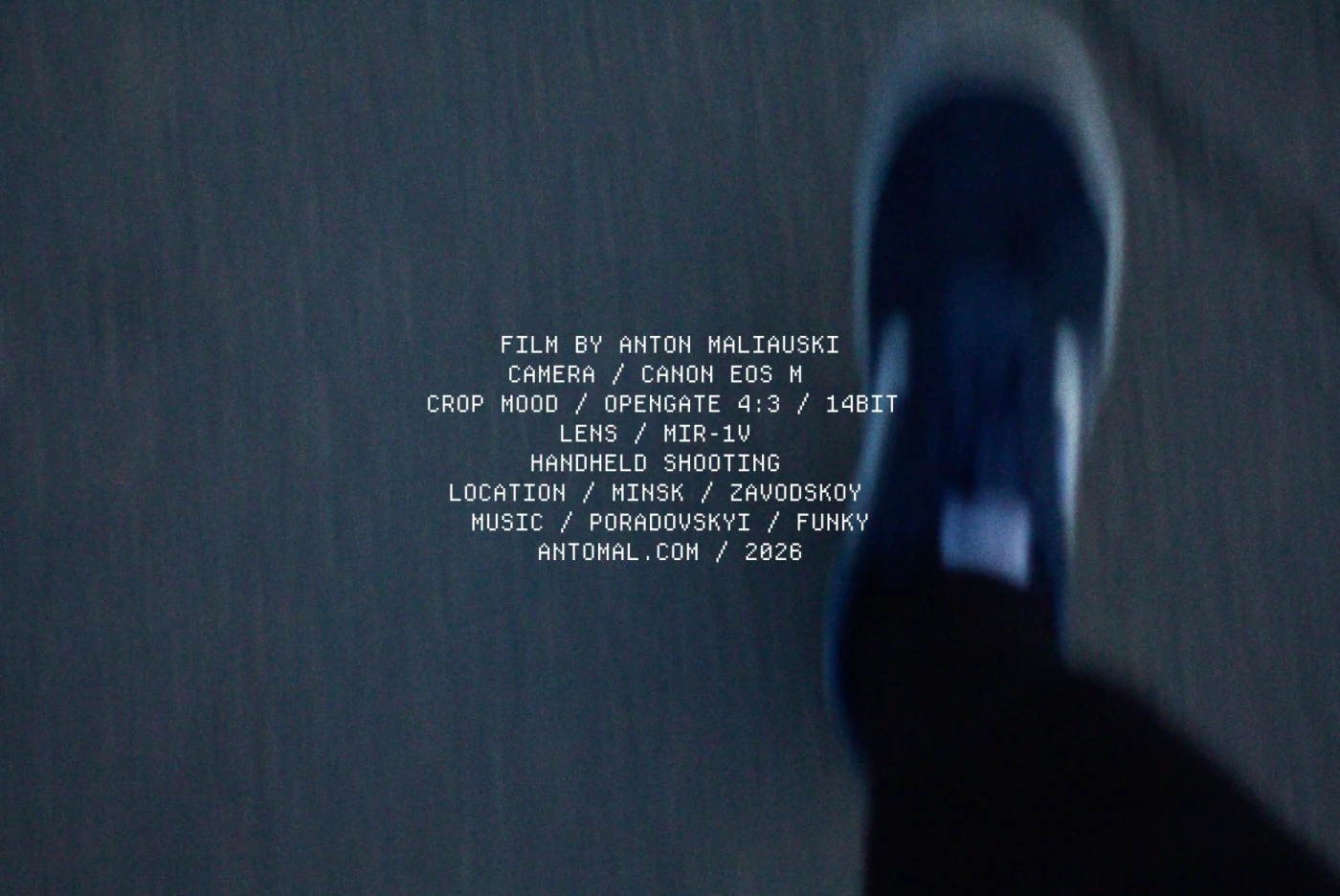 A foot in a blue sneaker on asphalt. Text: “FILM BY ANTON MALIAUSKI”, with camera and music information.