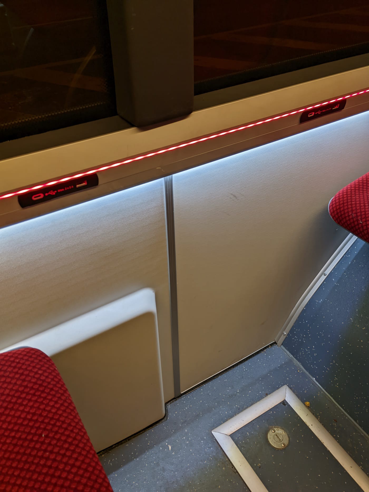 Фотография красной светодиодной ленты под окном в троллейбусе